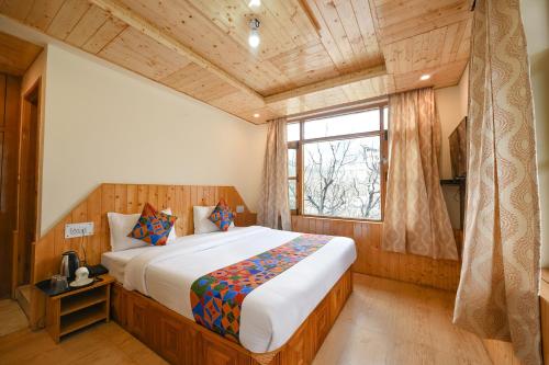 a bedroom with a large bed in a room with a window at Misty Hills in Manāli