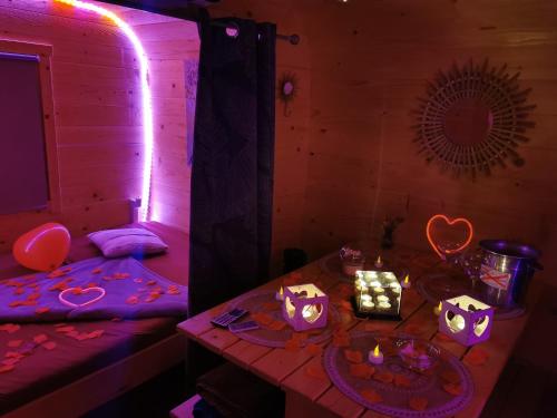 una camera con un letto e un tavolo con candele di Magnifique chalet Atypique avec Spa sous bulle privatif a Lanthenay