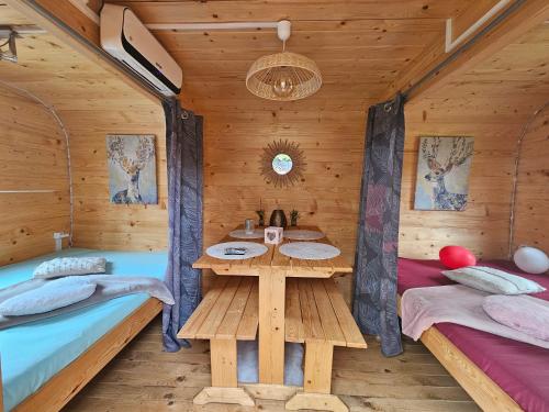 una camera con due letti e un tavolo in una cabina di Magnifique chalet Atypique avec Spa sous bulle privatif a Lanthenay