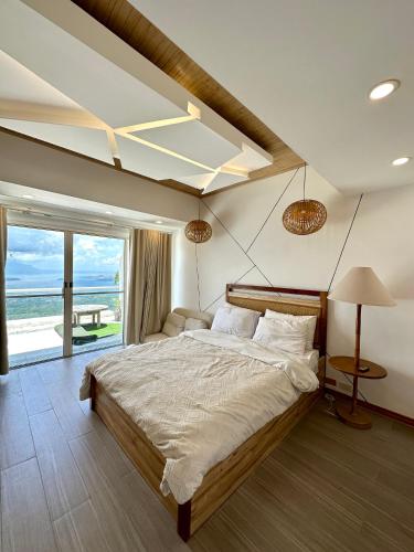 a bedroom with a large bed and a large window at 2 BR Lime Penthouse, Tagaytay Highlands in Tagaytay