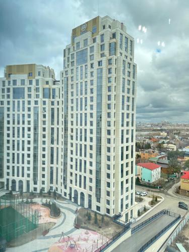 Un alto edificio bianco con una strada davanti di Esil Riverside Elite Apartments a Astana