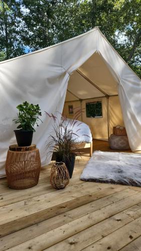 a tent with a bed and two plants in it at Coyote Point Lodge in Delta