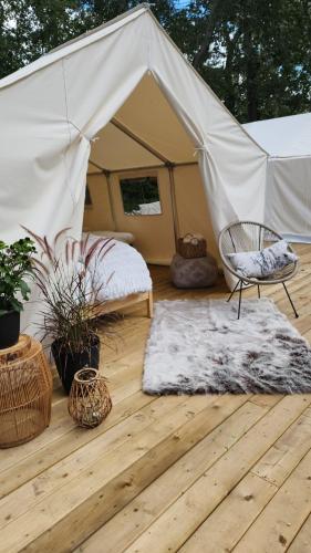 une tente avec un lit, une chaise et un tapis dans l'établissement Coyote Point Lodge, à Delta