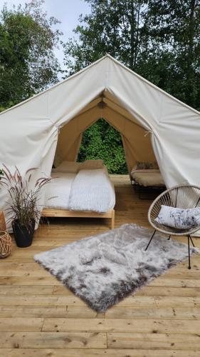 Tenda con letto, sedia e tappeto di Coyote Point Lodge a Delta