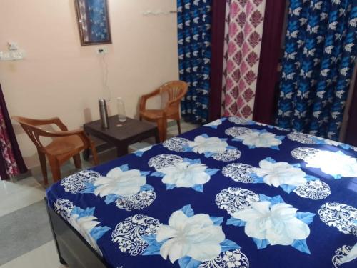 a bedroom with a blue bed with white flowers on it at Dev Bhoomi Home Stay in Marchula