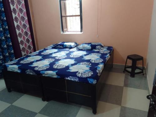 a bedroom with a bed with a blue comforter at Dev Bhoomi Home Stay in Marchula