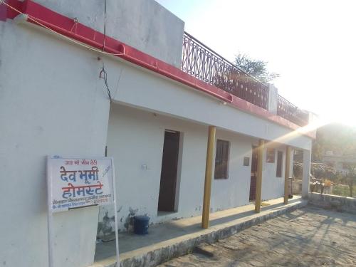 a white building with a balcony on top of it at Dev Bhoomi Home Stay in Marchula