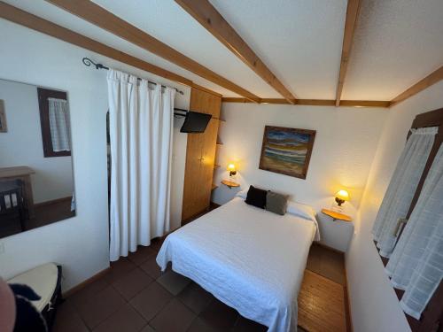 a bedroom with a white bed and two lamps at La Cerca Del Alcornoque in Casas de Belvis