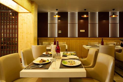 a dining room with a table with plates of food at Airport hotel deep palace near international airport in New Delhi