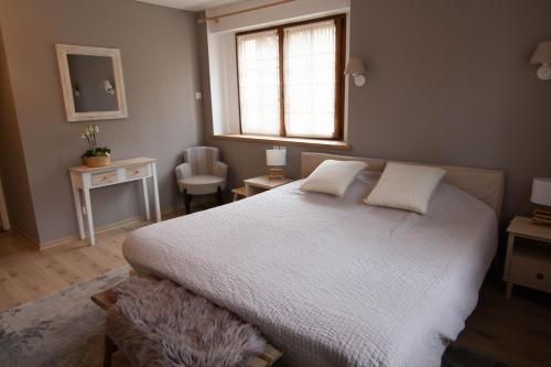ein Schlafzimmer mit einem weißen Bett und einem Fenster in der Unterkunft Sechex Nous in Margencel