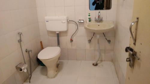 La petite salle de bains est pourvue de toilettes et d'un lavabo. dans l'établissement Kandi Orchard Resort, à Mussoorie