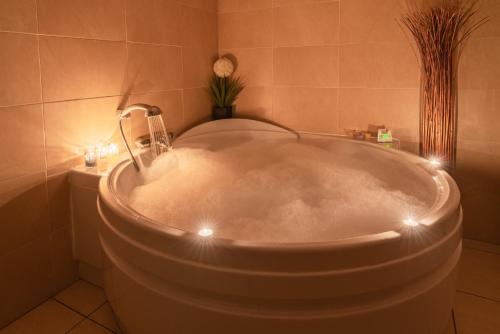 een badkamer met een bad met verlichting bij Hotel Tierra in Don Benito