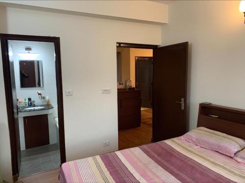 a bedroom with a bed and a sink and a mirror at Sweet Home Hattiban in Pātan