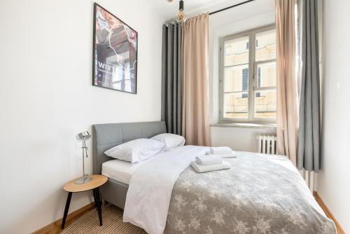 a small bedroom with a bed and a window at New Town Market Place Apartment in Warsaw