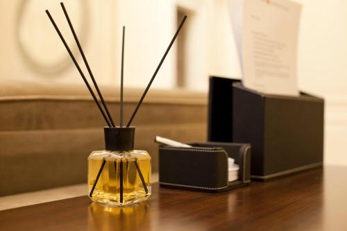 a glass vase with sticks in it on a table at Tiffi Old Town Hotel in Warsaw