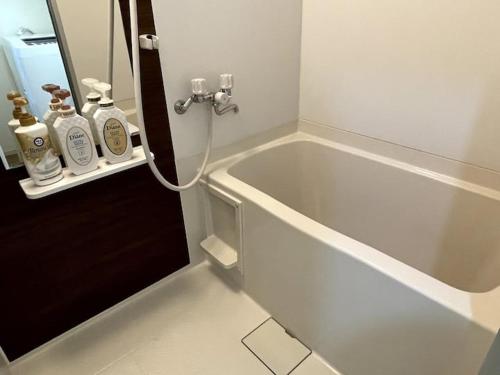 a bathroom with a bath tub and a sink at Nishi-Ike Apartment Room 2 in Tokyo