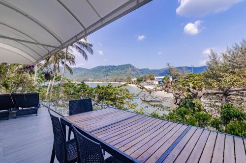 a table and chairs on a deck with a view of the water at Kamala Beach Estate Resort - SHA Extra Plus in Kamala Beach