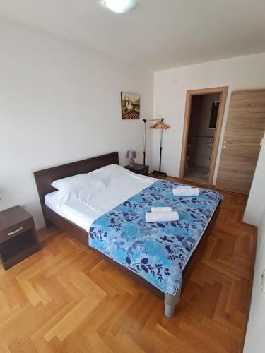 a bedroom with a bed with a blue blanket on it at Belveder Montenegro in Rafailovici
