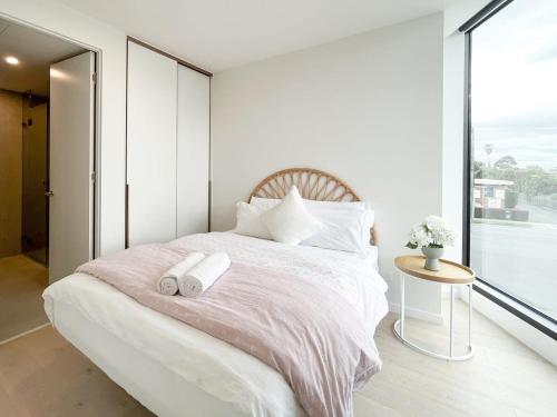 1 dormitorio con 1 cama grande y 2 toallas. en Modern Luxury 2B2B Sky Garden SmartTV, en Glen Waverley