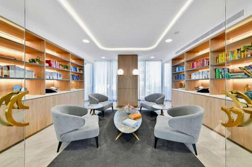 a library with chairs and a table and bookshelves at Modern Luxury 2B2B Sky Garden SmartTV in Glen Waverley