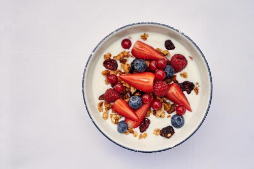 a plate of fruit and cereal on a white background at Hotel KÜGLERHOF in Tirolo