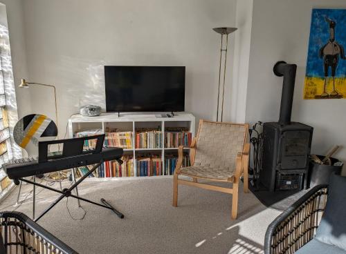 a living room with a chair and a television at Værelse som dobbelt el. enkelt, Engen 5, 7770 Vestervig in Vestervig