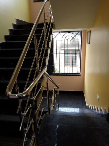 a metal staircase in an empty room with a window at Hotel Red Velvet in kolkata