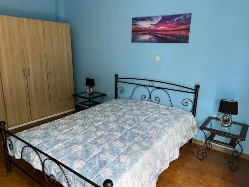 1 dormitorio con 1 cama con 2 mesitas de noche y 2 lámparas en Sofi's apartment, en Agios Konstantinos
