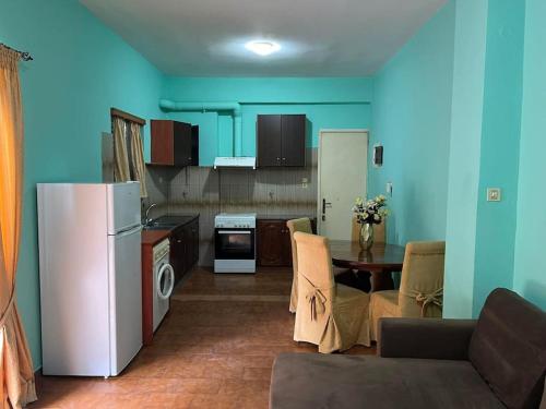 cocina con nevera y mesa en una habitación en Sofi's apartment, en Agios Konstantinos