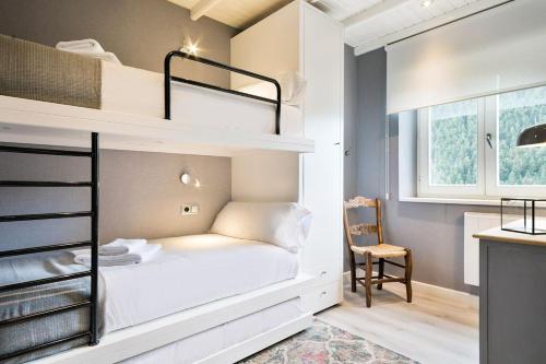 um pequeno quarto com um beliche e uma cadeira em Luderna - Apartamento Cap de Aran A2 em Baqueira-Beret