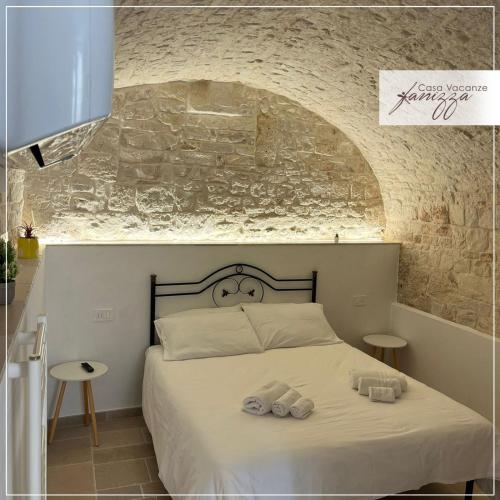 a bedroom with a bed with two towels on it at Himeros Trulli Area in Alberobello