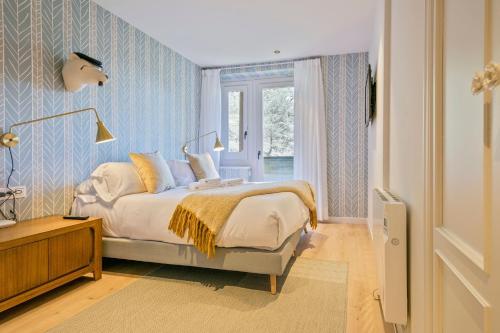 sypialnia z łóżkiem z niebiesko-białą tapetą w obiekcie Luderna - Apartamento con terraza Bonaigua A4 Varicauba w mieście Baqueira-Beret