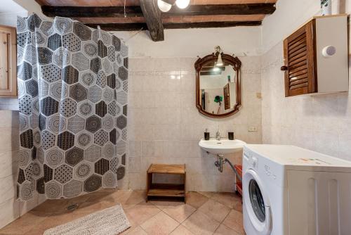 uma casa de banho com uma máquina de lavar roupa e um lavatório em Agriturismo Il Ponte em Vicchio