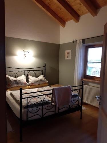 um quarto com uma cama preta e uma luz na parede em Ferienwohnung Bartl em Prien am Chiemsee
