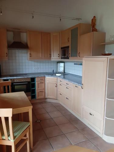 uma cozinha com armários brancos e uma mesa em Ferienwohnung Bartl em Prien am Chiemsee