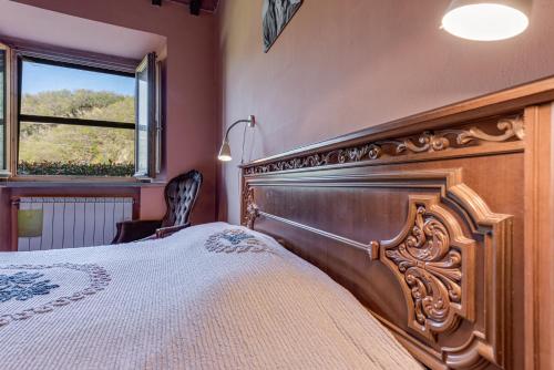 um quarto com uma cama de madeira e uma janela em Agriturismo Il Ponte em Vicchio