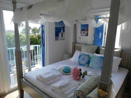a bedroom with a white bed with a balcony at Greek Island Style 2 bedroom Villa with Pool next to the Sea in Larnaka