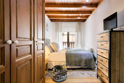 une chambre avec un lit et une commode avec une télévision dans l'établissement Luderna - Apartamento Val de Ruda A2 Comalada, à Baqueira-Beret