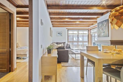 cocina y sala de estar con mesa y sofá en Luderna - Apartamento Val de Ruda B14 Paulet, en Baqueira Beret
