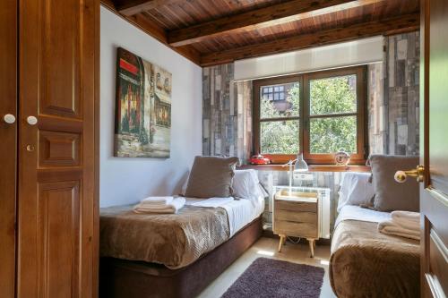 een slaapkamer met 2 bedden en een raam bij Luderna - Apartamento Val de Ruda B21 Blanhiblar in Baqueira-Beret