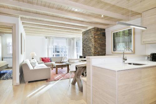 eine Küche und ein Wohnzimmer mit einem Sofa und einem Tisch in der Unterkunft Luderna - Apartamento Val de Ruda B26 des Garonets in Baqueira-Beret