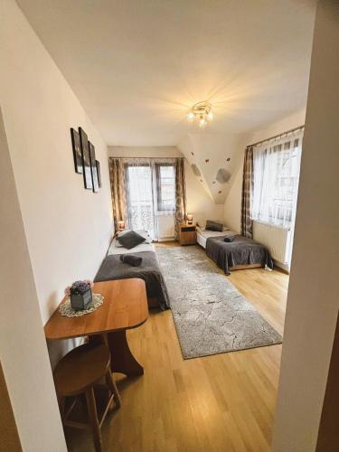 a large room with two beds and a table at Czarne jagody in Kościelisko