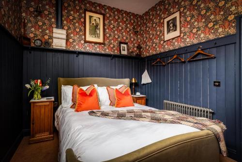 a bedroom with a bed with orange pillows and blue walls at Old Town Luxury, By The Sea in Scarborough