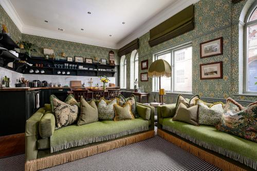 a living room with two green couches and pillows at Old Town Luxury, By The Sea in Scarborough