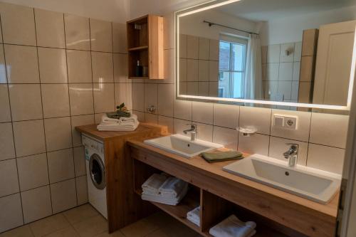 uma casa de banho com 2 lavatórios e uma máquina de lavar roupa em Apartment Weingut Zail em Appiano sulla Strada del Vino