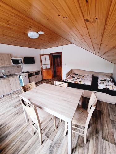 a kitchen and dining room with a table and chairs at Apartmány na Farmě in Kurdějov