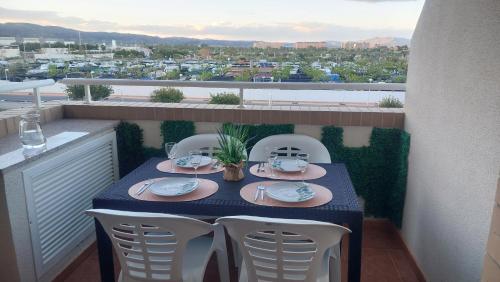 een tafel en stoelen op een balkon met uitzicht bij Green Beach -2 Dormitorios in Oropesa del Mar