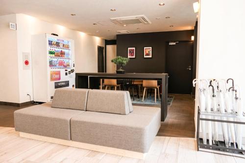 a living room with a couch and a table at WAYFARER Matsu in Osaka