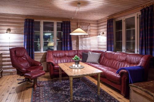 a living room with a red leather couch and a table at Knaben Utleie 