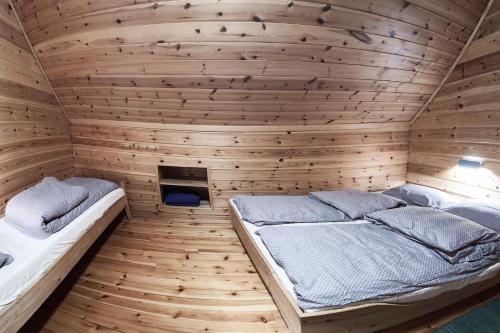 a bedroom with two beds in a wooden room at Knaben Utleie 